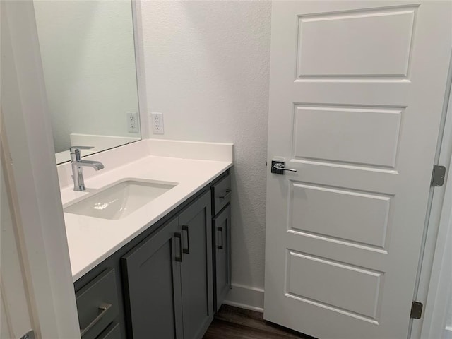 bathroom featuring vanity, wood finished floors, and a textured wall