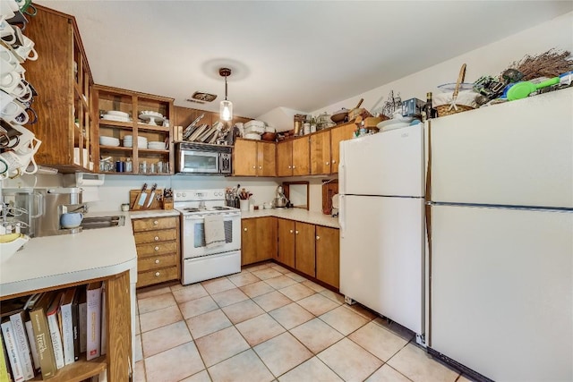 kitchen with light tile patterned floors, white appliances, and hanging light fixtures