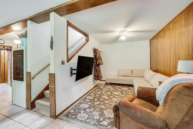 tiled living room featuring ceiling fan and wooden walls