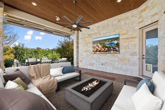 view of patio featuring ceiling fan and an outdoor living space with a fire pit