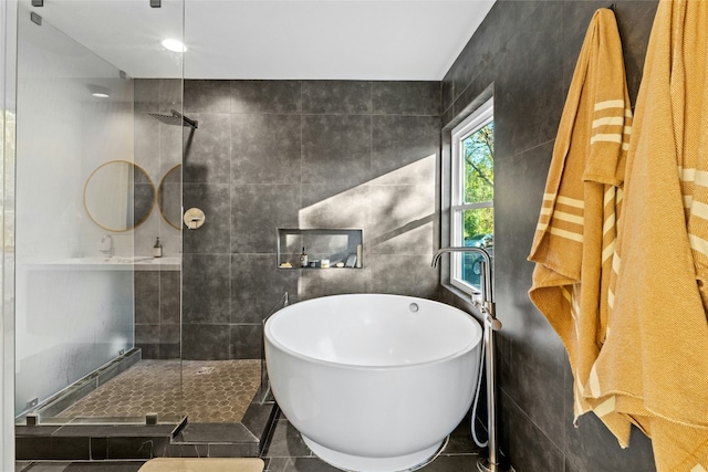 bathroom featuring plus walk in shower, tile walls, and tile patterned floors