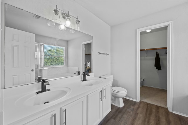 bathroom with hardwood / wood-style floors, vanity, and toilet