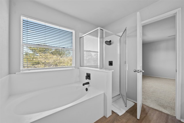 bathroom with plus walk in shower and hardwood / wood-style floors