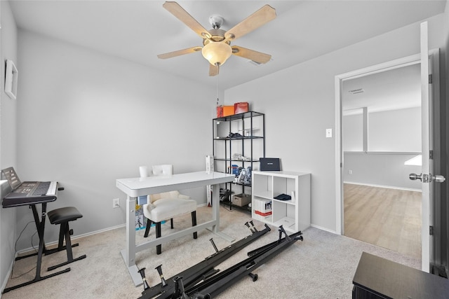 carpeted office space featuring ceiling fan