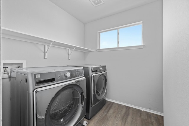 clothes washing area featuring dark hardwood / wood-style flooring and independent washer and dryer