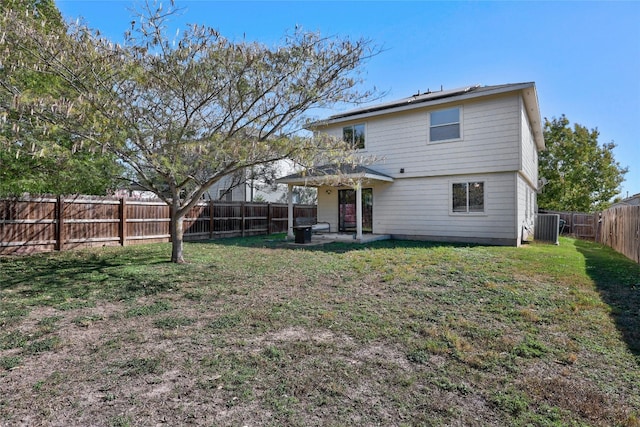 back of house featuring a lawn, cooling unit, and a patio