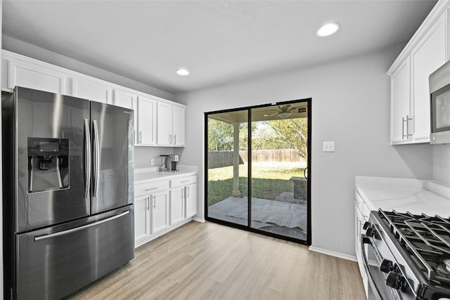 kitchen with white cabinets, light hardwood / wood-style floors, light stone counters, and appliances with stainless steel finishes