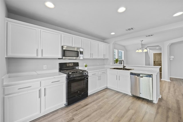 kitchen featuring sink, stainless steel appliances, kitchen peninsula, decorative light fixtures, and white cabinets