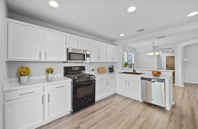 kitchen with pendant lighting, sink, white cabinetry, kitchen peninsula, and stainless steel appliances