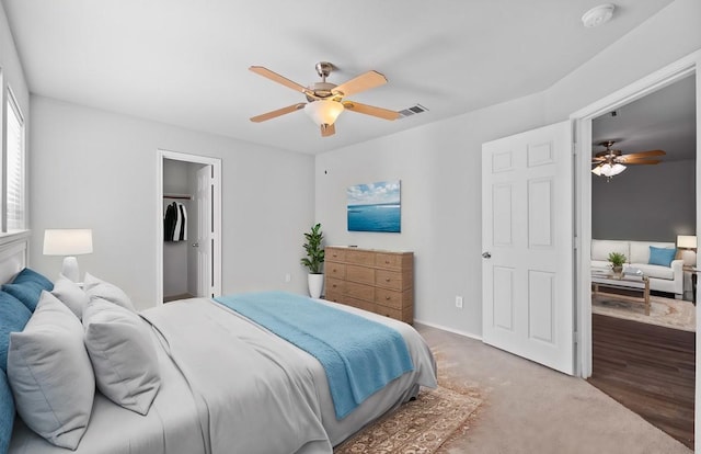 bedroom with ceiling fan, a closet, a spacious closet, and hardwood / wood-style flooring