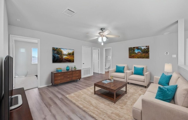 living room featuring ceiling fan and light wood-type flooring