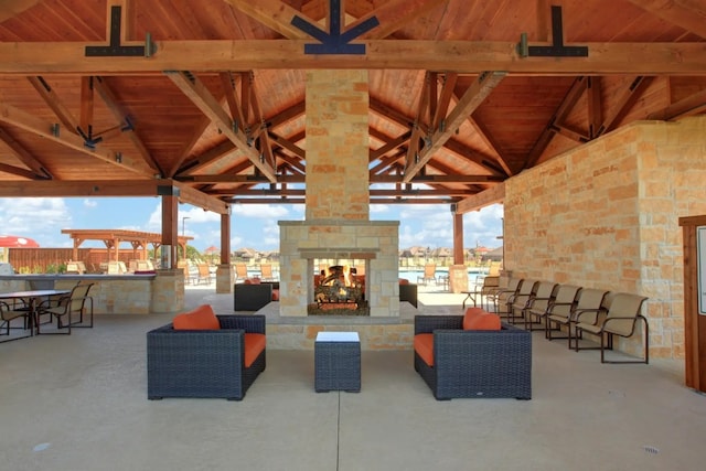 view of patio / terrace featuring an outdoor stone fireplace and a gazebo