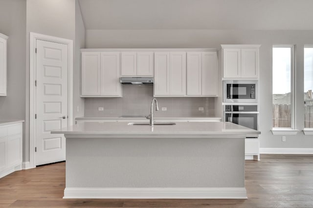 325 Crescent Heights Dr, Georgetown, TX 78628 - kitchen with under cabinet range hood, built in microwave, oven, decorative backsplash, and light countertops