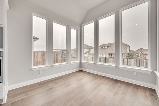 unfurnished sunroom featuring vaulted ceiling