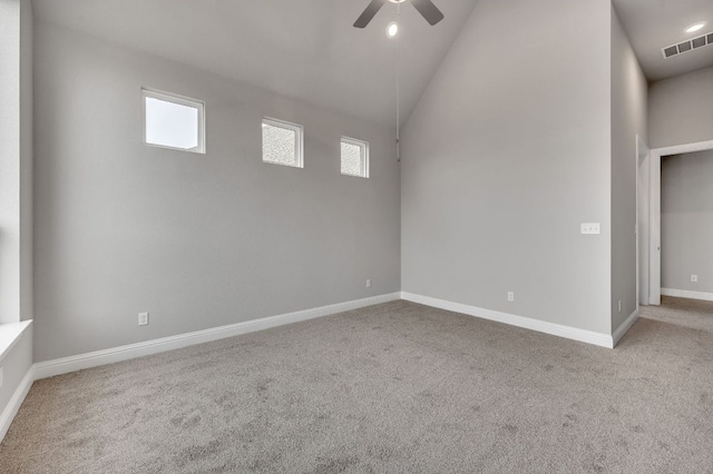 carpeted spare room with high vaulted ceiling, a ceiling fan, visible vents, and a healthy amount of sunlight