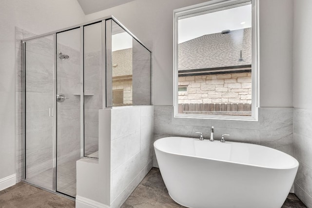 325 Crescent Heights Dr, Georgetown, TX 78628 - bathroom featuring wainscoting, a freestanding tub, a shower stall, and tile walls