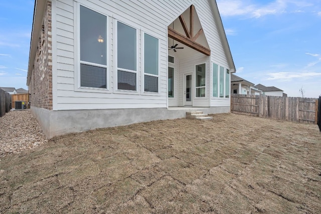 back of property featuring ceiling fan, cooling unit, and fence