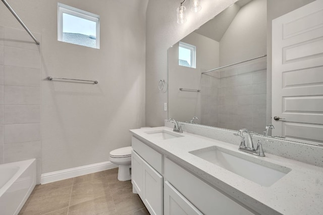 bathroom featuring toilet, double vanity, baseboards, and a sink