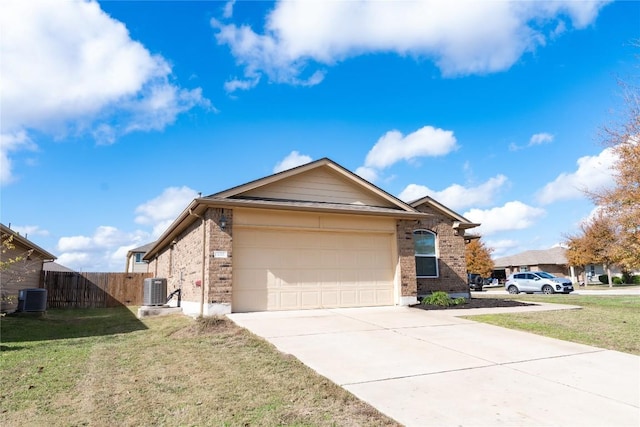 view of front of house with a front lawn, central AC unit, and a garage