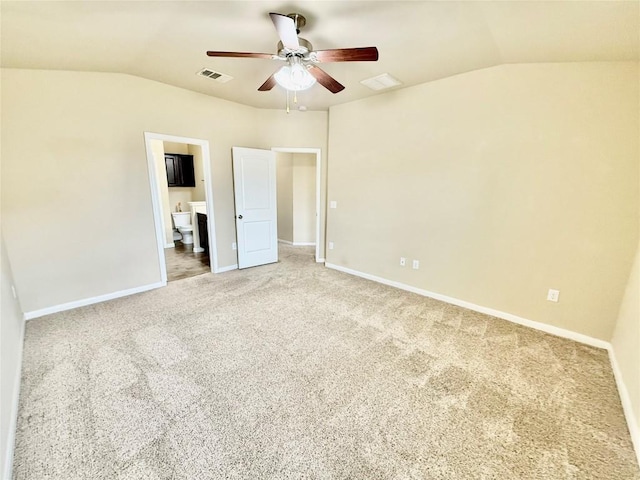 unfurnished bedroom featuring vaulted ceiling, carpet, ensuite bathroom, and ceiling fan