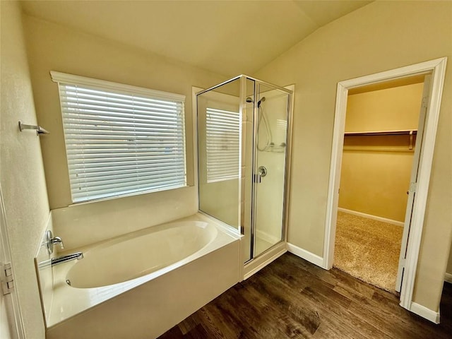 bathroom featuring independent shower and bath, wood-type flooring, and lofted ceiling