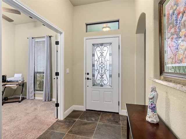 carpeted entryway featuring ceiling fan