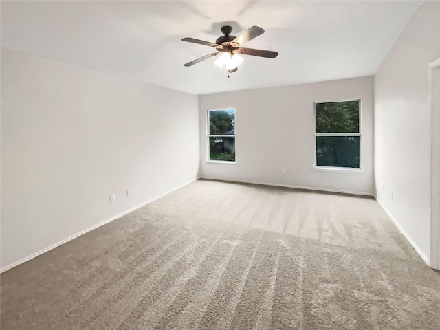 spare room with ceiling fan and light colored carpet