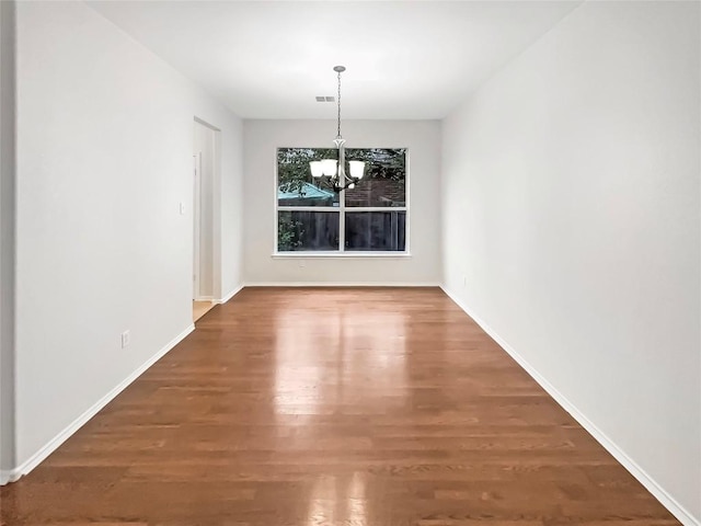 unfurnished dining area with dark hardwood / wood-style flooring and a notable chandelier