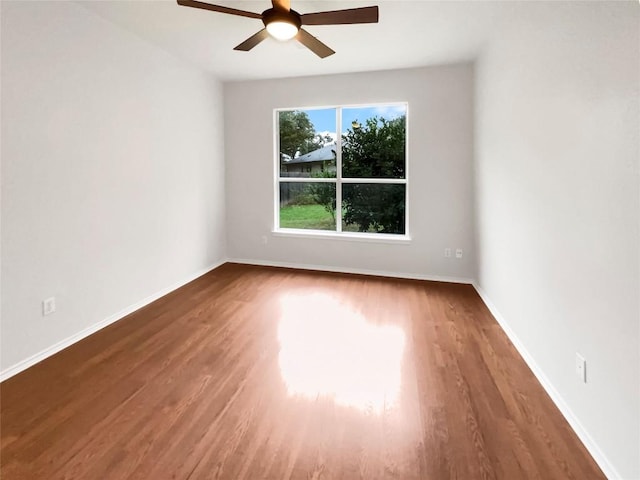 empty room featuring ceiling fan and dark wood-type flooring