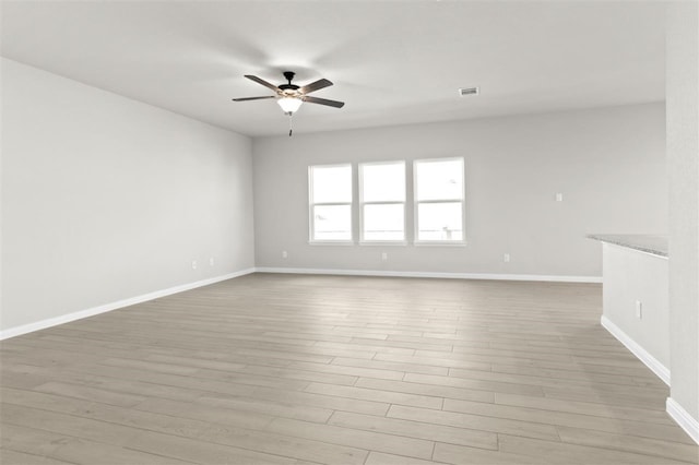 spare room with light wood-type flooring and ceiling fan