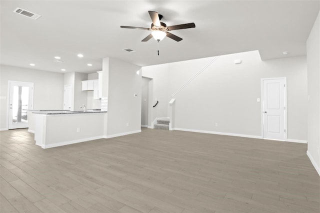 unfurnished living room with light hardwood / wood-style floors and ceiling fan