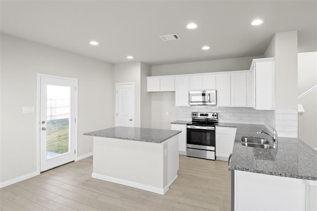 kitchen with white cabinets, light hardwood / wood-style floors, sink, and stainless steel appliances