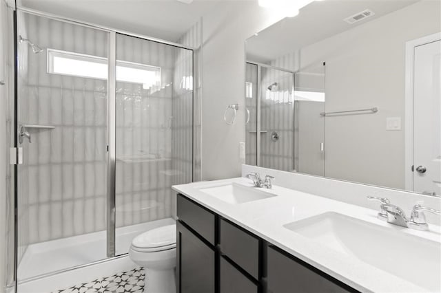 bathroom featuring tile patterned floors, vanity, toilet, and an enclosed shower