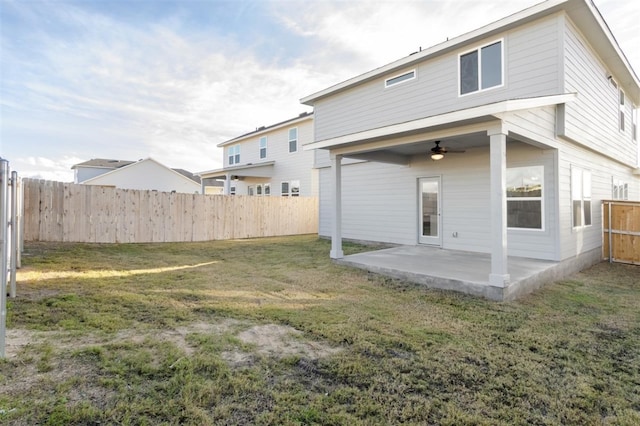 rear view of property with a patio area, ceiling fan, and a yard