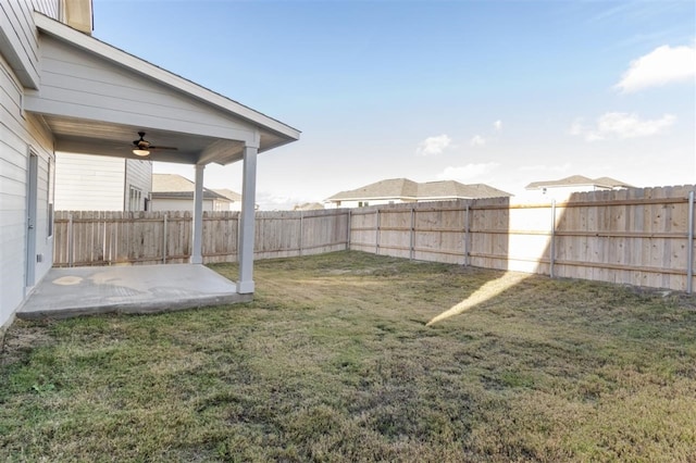 view of yard with ceiling fan and a patio