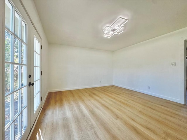 unfurnished room with french doors and light hardwood / wood-style flooring