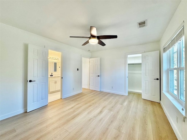 unfurnished bedroom featuring ceiling fan, light wood-type flooring, and multiple windows