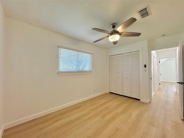 unfurnished bedroom with ceiling fan, a closet, and light wood-type flooring