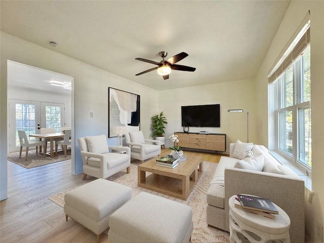 living room featuring ceiling fan, light hardwood / wood-style floors, and french doors