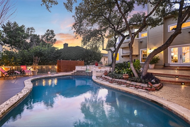 pool at dusk with french doors