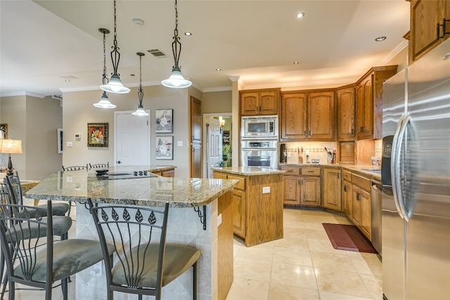 kitchen featuring hanging light fixtures, a center island, stainless steel appliances, and a kitchen breakfast bar