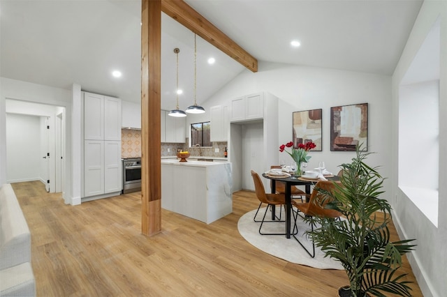 kitchen with hanging light fixtures, backsplash, lofted ceiling with beams, light hardwood / wood-style floors, and white cabinets