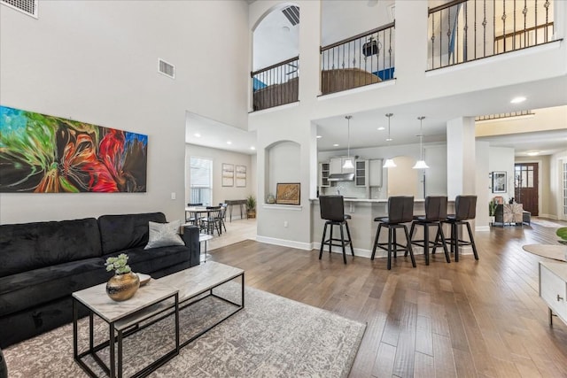 living room with a high ceiling and hardwood / wood-style floors