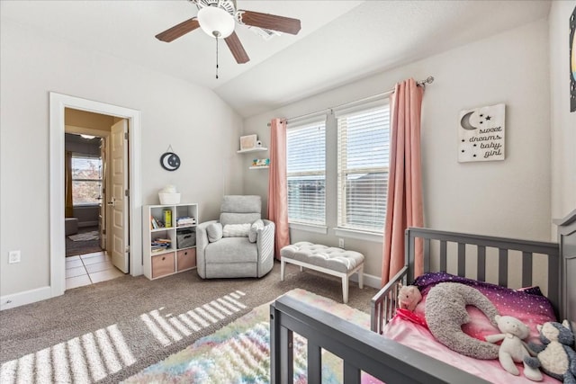 carpeted bedroom featuring ensuite bath, multiple windows, lofted ceiling, and ceiling fan