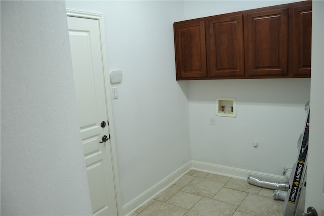 laundry room with hookup for a gas dryer, hookup for a washing machine, light tile patterned floors, and cabinets