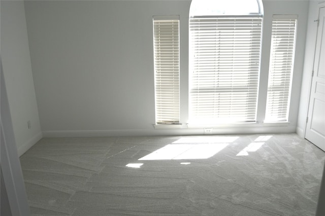 spare room featuring light carpet and a wealth of natural light