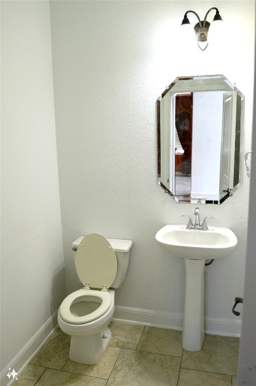 bathroom with tile patterned flooring, toilet, and sink