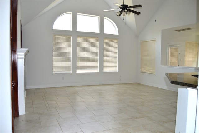 unfurnished living room featuring ceiling fan, high vaulted ceiling, and light tile patterned floors