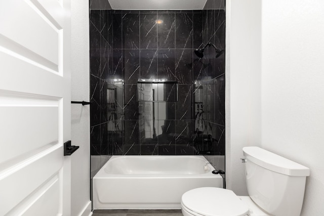 bathroom with tiled shower / bath combo and toilet