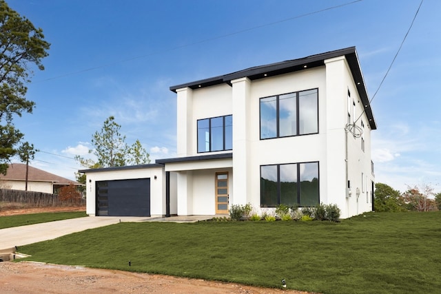 modern home featuring driveway, stucco siding, a front yard, and a garage